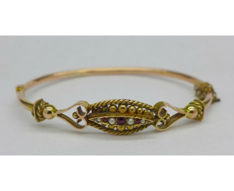 A 9ct gold, ruby and seed pearl bangle, 6.3g