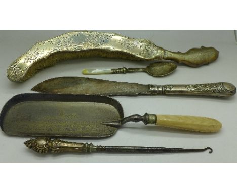 A continental silver backed crumb brush, a silver handled button hook, a plated crumb scoop, a fish server and a spoon