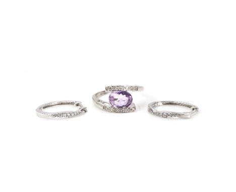 A 9ct white gold amethyst and diamond ring and a pair of diamond earrings, the ring with an oval cut amethyst, tension set to