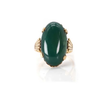 A dyed green chalcedony ring,  with an oval dyed green chalcedony cabochon, claw set to a scalloped mount, into shoulders wit