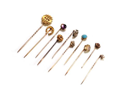 A collection of Victorian and Edwardian stick pins, to include a ruby horseshoe stick pin, tested as approximately 14ct gold,