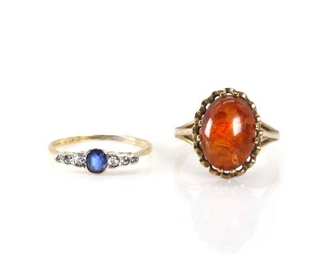 A sapphire and diamond ring and a 9ct gold amber ring, with an oval cut sapphire, flanked by a line of graduated eight cut di