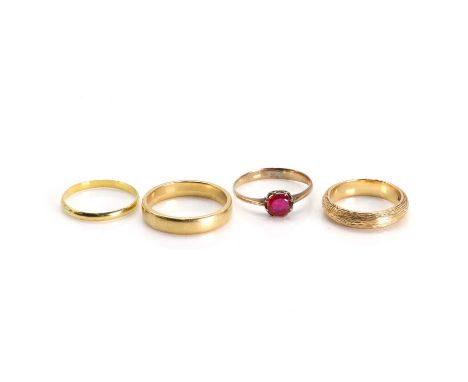 A group of four rings, including three 18ct gold bands, one of textured finish, ring size M, a flat court band, ring size R a