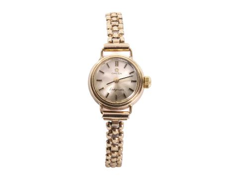 A 9ct gold Omega Ladymatic automatic bracelet watch, with a 17mm diameter case, a silvered dial, gilt batons, black baton han