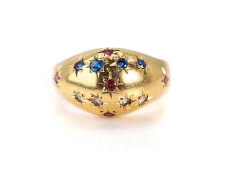 A Portuguese gold bombé ring,  star set with synthetic rubies, blue and colourless synthetic spinel, to a tapering plain hoop