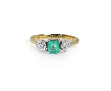 An 18ct gold emerald and diamond three stone ring,  centrally set with an octagonal step cut emerald, estimated as approximat