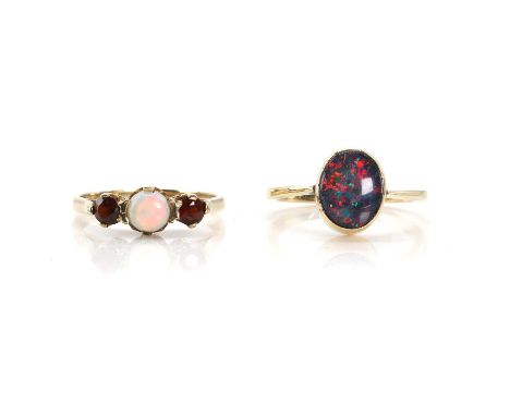 A 9ct gold opal and garnet ring and an opal triplet ring, with a central round opal cabochon, to a round cut garnet to either