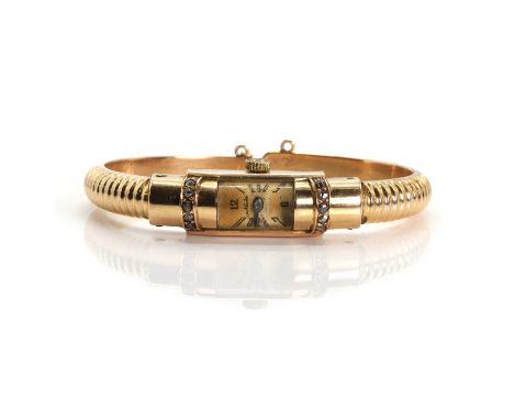 A ladies' gold diamond mechanical bracelet watch, with a domed rectangular case grain set with two lines of rose cut diamonds