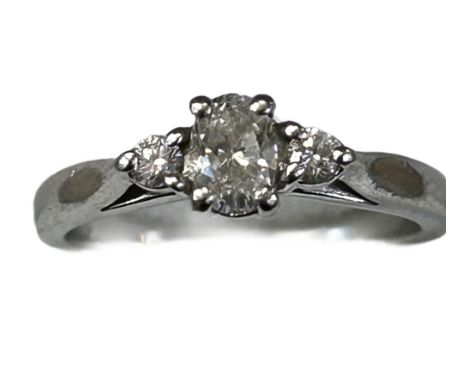 Platinum ring set with central oval cut diamond with 2 brilliant cut round diamonds either side. Very good diamonds Size K We