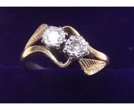 An 18 carat gold and platinum set diamond crossover ring - size N