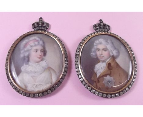 A pair of 19th century watercolour portrait miniatures of a gentleman and woman set in silver and paste frames with crown sur