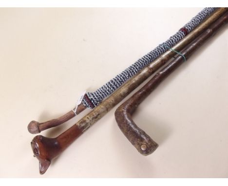 A beaded tribal stick, a stick with Egyptian cat handle and a walking stick