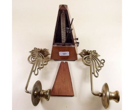 A pair of brass piano sconces and a metronome