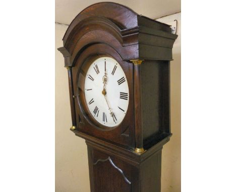 A George III oak longcase clock, the hood having an arched top and turned columns, over a painted arch door, the box base rai