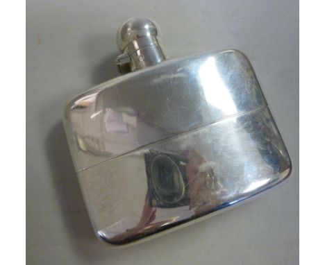 A silver hip flask of curved, cushion form with a sleeve cup and a rotating cap, on an outset hinge  Stokes & Ireland  Cheste