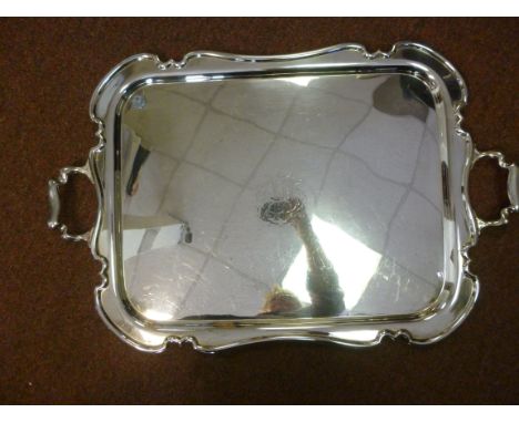 An Edwardian silver plated serving tray, having an applied, raised, serpentine outlined border and opposing carrying handles 