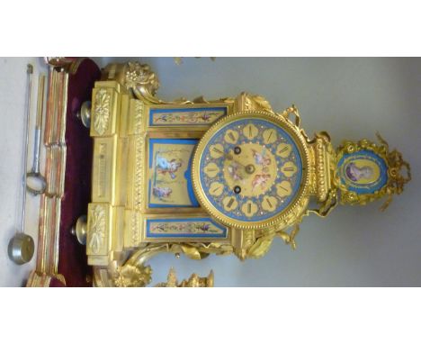 A late 19th/early 20thC ornately cast gilt metal cased mantel clock with painted porcelain panels, floral, foliate, fruiting 