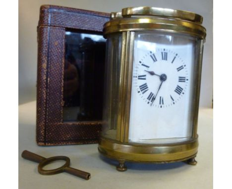 An early/mid 20thC oval lacquered brass cased carriage timepiece, having bevelled glass panels and a folding top handle, on b
