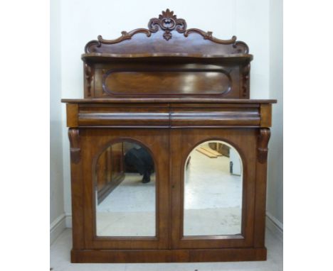 A late Victorian mahogany chiffonier, having a panelled, foliate scroll carved upstand, the base with two in-line, cushion mo