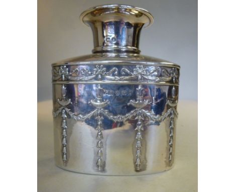 An Edwardian silver tea caddy of shouldered, oval form, having a button-top cap, embossed in neo-classical taste with ribbon 