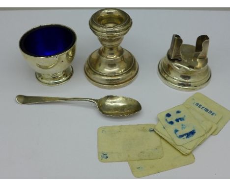 A small silver candlestick, a silver egg cup, a silver calendar a/f, and a silver spoon, a/f