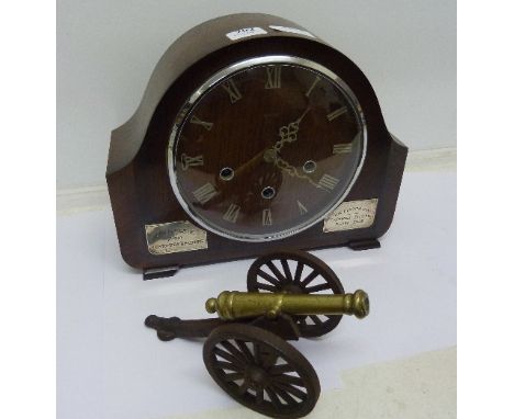 A Smiths mantel clock with chiming movement and a model cannon, clock bears presentation plaques