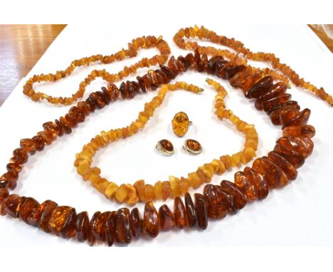 FOUR AMBER NECKLACES AND AN AMBER SILVER RING AND EARRINGS  comprising three rough amber necklaces, a rough polished and clar