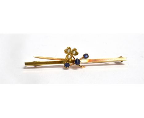 AN EDWARDIAN SMALL SAPPHIRE AND SEED PEARL SET YELLOW GOLD BAR BROOCH The shamrock design to plain bar, 5cms long, unmarked, 