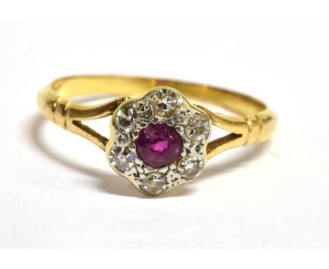 A RUBY AND DIAMOND 18 CT GOLD CLUSTER RING The round cluster comprising a small round cut ruby centre with small diamonds to 