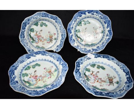 FOUR CHINESE DISHES  polychrome enamelled decoration of a seated lady and child with dog in a garden setting, within an under