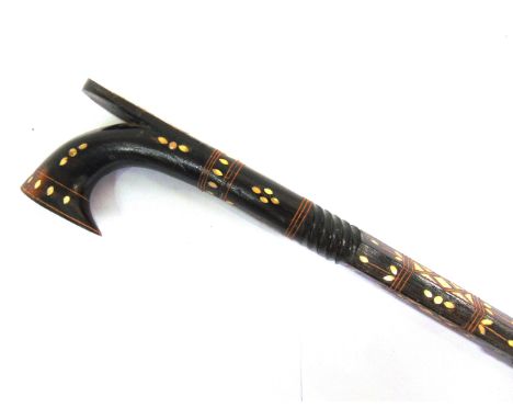 A PHILIPPINE CARVED WOOD WALKING STICK  with mother of pearl inlay, 99.5cm long.