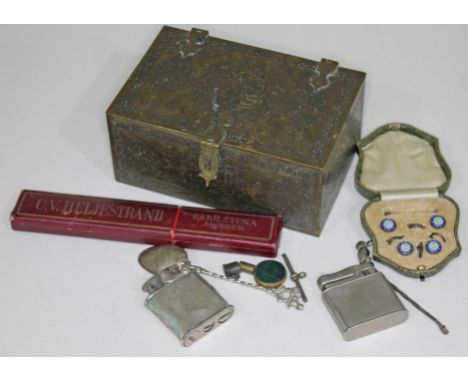 An Eastern brass box and contents including a razor, a sterling silver button set, two lighters etc.  