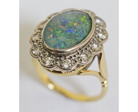 An opal doublet and diamond ring, the central stone approx. 13mm x 9mm, band marked '18ct', gross weight 6.4g, size L.  