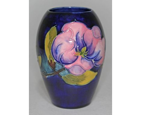 A Moorcroft pottery vase decorated in Pink Magnolia patter, height 12.5cm.  Condition - stick mark residue left from a sticke