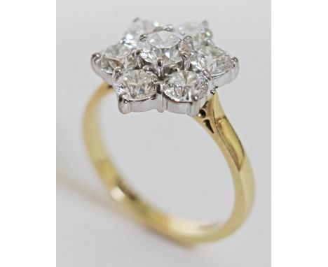 A seven stone diamond ring, the central stone approx. 0.63 carats, surround by six stones approx. 0.47 carats each, gross est