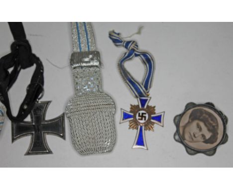 A mixed lot of German WWI &amp; WWII items comprising a WWI Iron Cross, a braided knife toggle, an enamel German WWII mother'