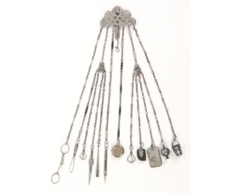 A mid 19th Century steel chatelaine, the shaped and pierced curved clip mount with seven various chains two subsequently divi