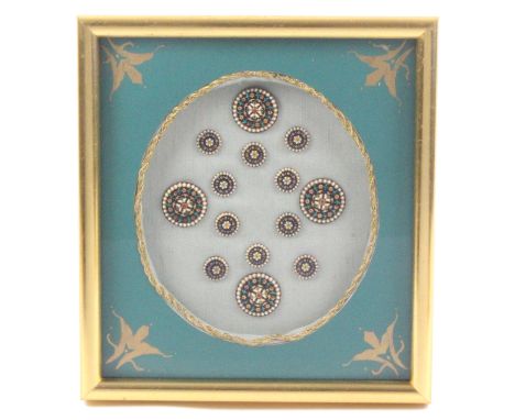 Buttons - a framed display of a set of fourteen early 19th Century enamel buttons, probably French, each with blue enamel gro