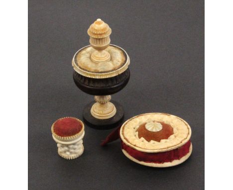 Three pin cushions, comprising a late 18th Century engine turned rosewood and ivory example of vase form surmounted by a mini