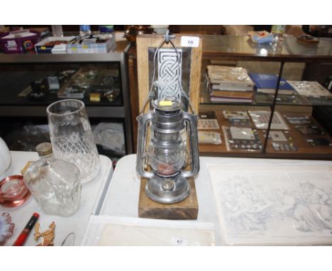A&nbsp;vintage hurricane lamp set to a mirrored wooden holder