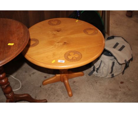 A light elm circular occasional table; decorated with the four suits of playing cards