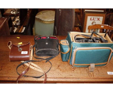 A Zenit camera; a pair of cased binoculars and another