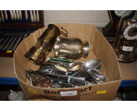 A box containing various plated cutlery, plated mug, miners lamp etc.