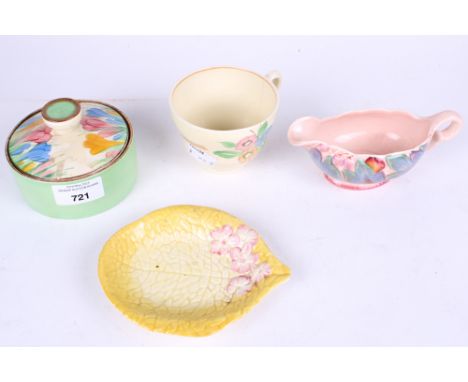 A collection of four assorted pieces of Clarice Cliff pottery. Including a yellow leaf dish, a pink jug #40A, a tea cup and a