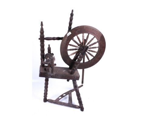 A 19th century spinning wheel. On bobbin turned supports, H102cm