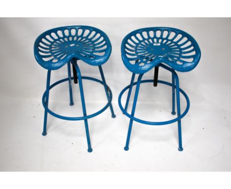 A pair of cast metal 'tractor seat' bar stools. Painted blue, adjustable height