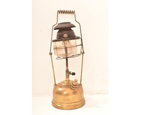 A Brass Tilley lamp of circular form with carrying handle and glass shade enclosed by a wire frame, Height 42cm x Width 15cm