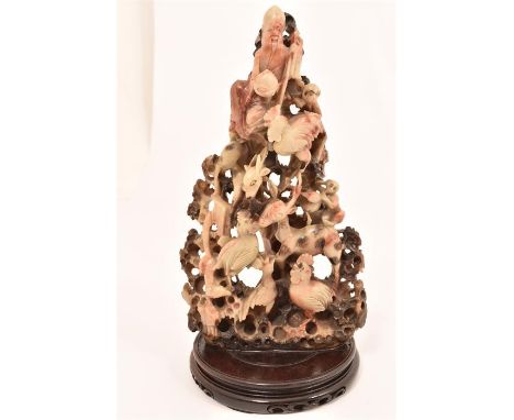 A large carved Chinese soapstone sculpture formed as animals including cockrels, deer, monkeys, etc; the top adorned with a m