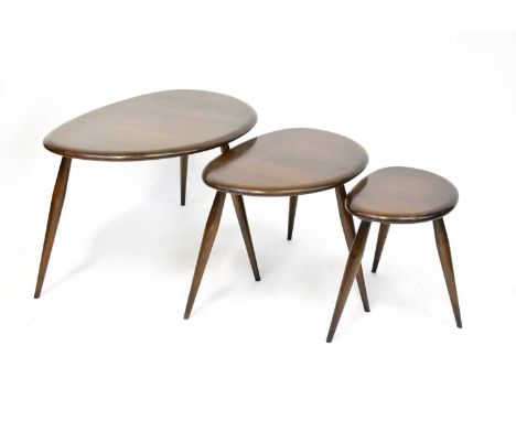 ERCOL; a nest of three pebble-shaped dark wood tables, on turned tapering legs, with original label ('Made in High Wycombe Bu