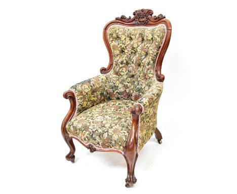 A Victorian walnut button back parlour chair, with carved scroll back and on squat cabriole legs, upholstered in a floral tap